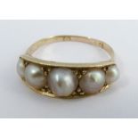 A Victorian five stone pearl ring, stamped '15', the split pearls (untested and unwarranted)