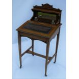 An Edwardian mahogany desk, the back fitted with a shelf over a mirror, with a pair of inkwells