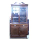 A 19th century mahogany glazed bookcase cabinet, with broken swan pediment over a pair of astragal