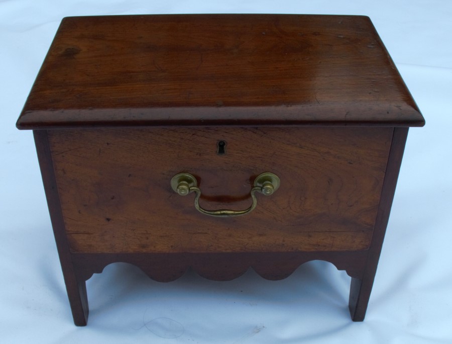 A Georgian mahogany single drawer box stool, having cut-out sides and shaped apron to the front, the