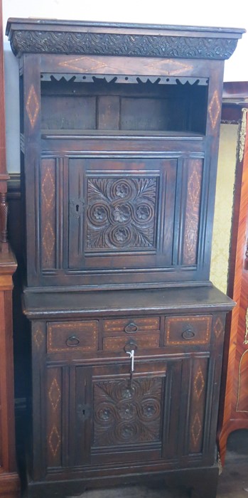 An Antique oak cabinet, the upper section fitted with a shelf over a cupboard, the base fitted