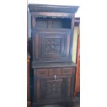 An Antique oak cabinet, the upper section fitted with a shelf over a cupboard, the base fitted