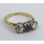 An 18 carat gold diamond and sapphire three stone ring, the two diamonds totalling approximately 0.5