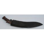 A Kukri style knife, with wooden handle, having a leather scabbard with two smaller knives