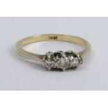 A three stone diamond ring, stamped '18ct', set with two single cuts and a brilliant cut, finger
