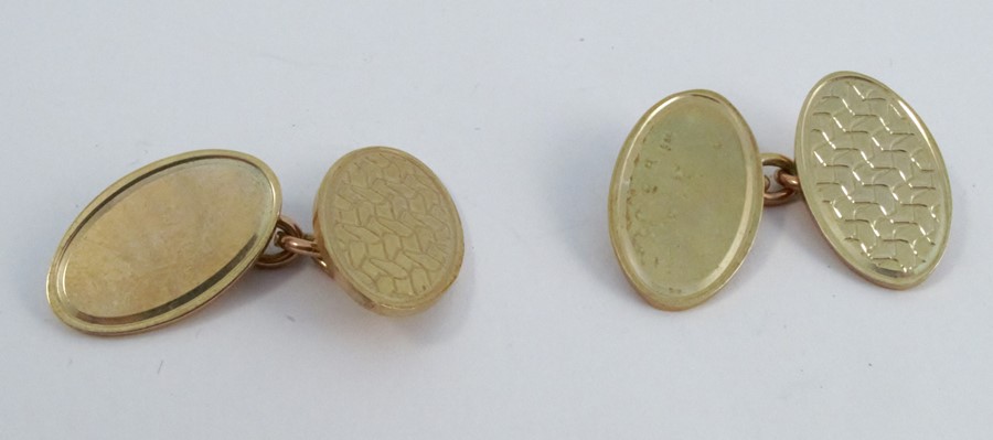 A pair of 9 carat gold cufflinks, the oval panels, one plain, one engine turned, with chain link