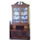 An Edwardian mahogany secretaire bookcase, the upper section with broken arched pediment and urn,