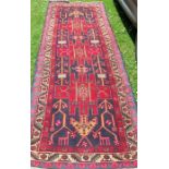 An Eastern style runner, decorated with stylised animals, flowers and repeating motifs, 120ins x