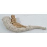 A 19th century clay pipe, moulded with leaves and a recumbent female nude, length 4.5ins