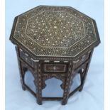 An Antique Eastern octagonal table, with folding base, the whole inlaid in ivory with leaves and