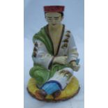 A painted terracotta garden ornament, of a seated Oriental figure, height 24ins