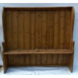 An Antique pine curved settle, with small canopy and shaped arms, height 61ins, width 63.5ins