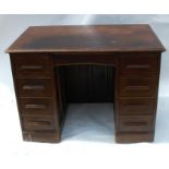 A 20th century oak kneehole desk, fitted with a frieze drawer flanked by slides and drawers, width