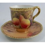 A Royal Worcester tea cup and saucer, the exterior of the cup and saucer decorated with fruit to a