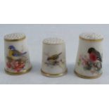 Three Royal Worcester thimbles, each decorated with English birds, one signed PowellCondition