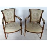 A pair of French style upholstered and show wood open armchairs, with carved decoration