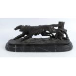 A metal model of two dogs running, on a marble base, signed Barye, height 5.25ins