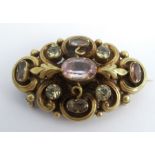A Victorian gem set gold brooch, of scroll and leaf design, locket back, 4.7cm long, 11g gross