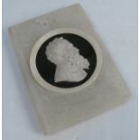 An alabaster paper weight, formed as a book, with carved portrait set on a black roundel, engraved
