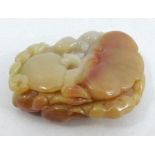 A Chinese caramel agate pendant, carved with monkey and bats among fungi, a peach and finger citrus,