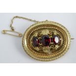 A Victorian oval three stone gold brooch, unmarked, locket back, 4.1cm long, 11g gross