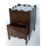 A George III mahogany bedside cabinet, with tray top, fitted with a drawer, over a cupboard over