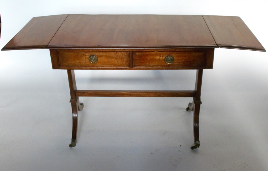 A mahogany sofa table, raised on reeded supports with brass caps and casters, depth 22ins, width