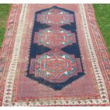 An Eastern design rug, the field with three motifs to a dark blue ground, 73ins x 48ins