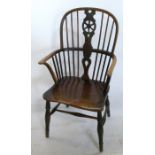 An Antique Windsor armchair, with wheel splat back, raised on turned legs with H stretcher