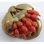 A Victorian oval gold brooch, unmarked, with coral set 'fruiting vine', 3.6cm across, 9g gross