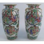 A pair of Chinese porcelain vases, decorated with reserve of figures to a floral decorated ground,