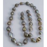 A row of baroque large cultured pearls, 70cm long, to a metal clasp, in a Gump's wallet and card
