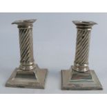 A pair of silver candle sticks, with bead edge, wrythern fluted columns, raised on square bases with