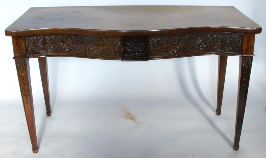 A George III style mahogany serpentine fronted sidetable, fitted with two frieze drawers with carved