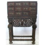 An Antique Portuguese hardwood cabinet on stand, having twelve drawers, with fluted moulded