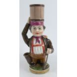 A 19th century Niderviller porcelain candlestick figure, modelled as a dwarf with a barrel on his