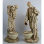 A pair of Royal Worcester blushed ivory figures, of Eastern water carriers, modelled as a man and