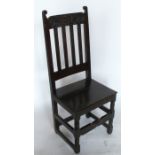 An Antique oak hall chair, with carved decoration and solid seat