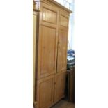 A pine cupboard, having a pair of double fielded doors opening to reveal a shelves, with another