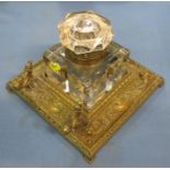 A 19th century brass inkwell stand, the square glass inkwell with brass hinge, mounted on a square