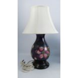 A Moorcroft pottery lamp base, of baluster form, decorated in the Anemone pattern, on a wooden base,