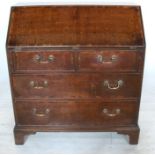 An Antique oak bureau, the fall flap opening to reveal with a cupboard, drawers and pigeon holes,