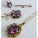An amethyst pendant, on a chain, together with a matching brooch, an amethyst bar brooch, and an