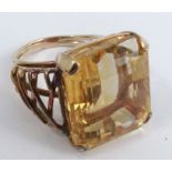 A large citrine ring, in unmarked yellow metal, the stepcut stone approximately 7.7mm by 5.4mm by