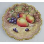 A Royal Worcester cabinet plate, decorated with fruit to a mossy background by H Aryton, with gilded