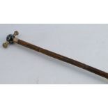 A Victorian walking cane, the handle with porcelain ball decorated with figures and having 18ct gold