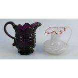 Two 19th century glass jugs, one amethyst pressed glass with trail handle, the other probably St