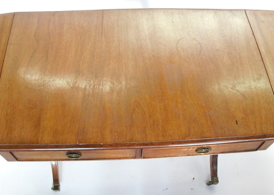 A mahogany sofa table, raised on reeded supports with brass caps and casters, depth 22ins, width - Image 2 of 2