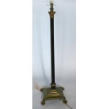A brass standard lamp, formed as a Cornintian column, raised on a stepped base and paw feet,