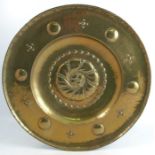 A circular pressed brass dish, decorated with a central flower head, diameter 21ins